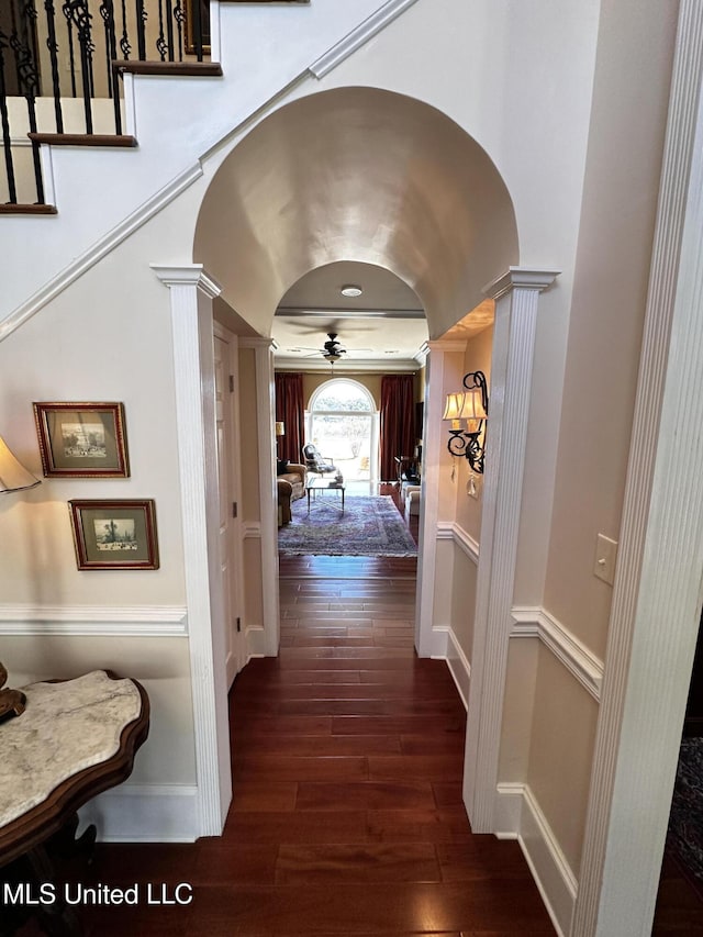 hallway featuring ornate columns and dark wood-type flooring