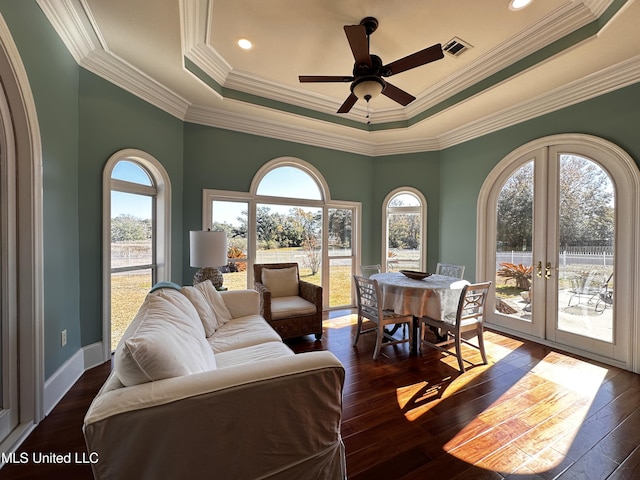 living room featuring french doors, crown molding, a raised ceiling, and dark wood-type flooring