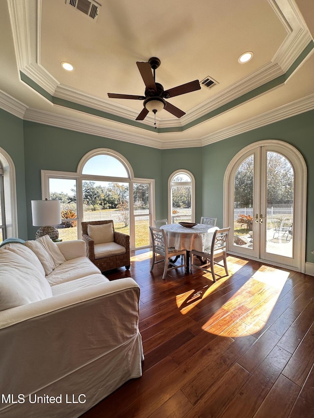 living room featuring french doors, crown molding, a tray ceiling, dark hardwood / wood-style flooring, and ceiling fan