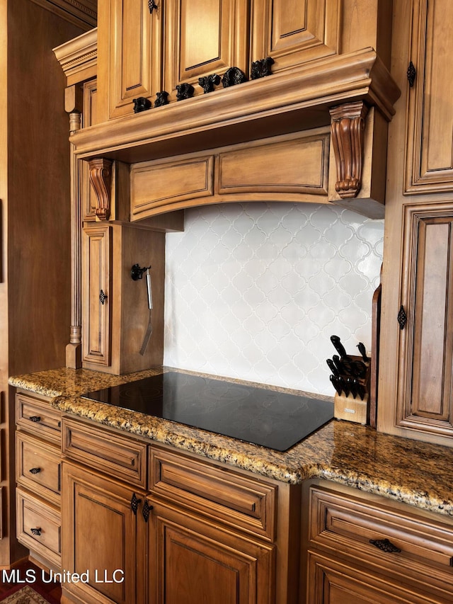 kitchen featuring black electric cooktop, tasteful backsplash, and stone counters