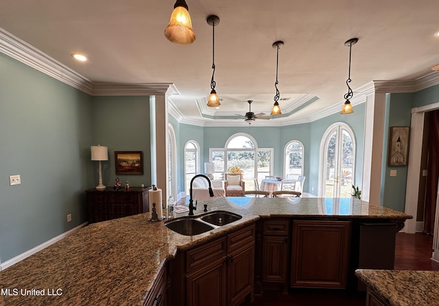 kitchen featuring crown molding, sink, pendant lighting, and light stone counters