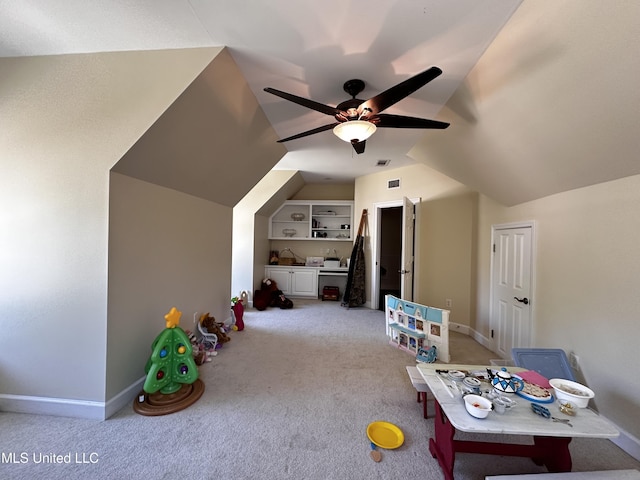 rec room featuring vaulted ceiling, light carpet, ceiling fan, and built in shelves