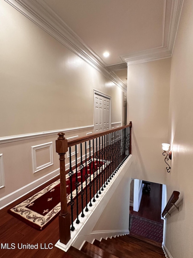 staircase with crown molding and wood-type flooring