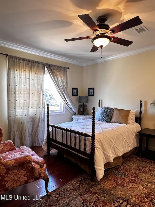 bedroom featuring dark wood-type flooring, ornamental molding, and ceiling fan