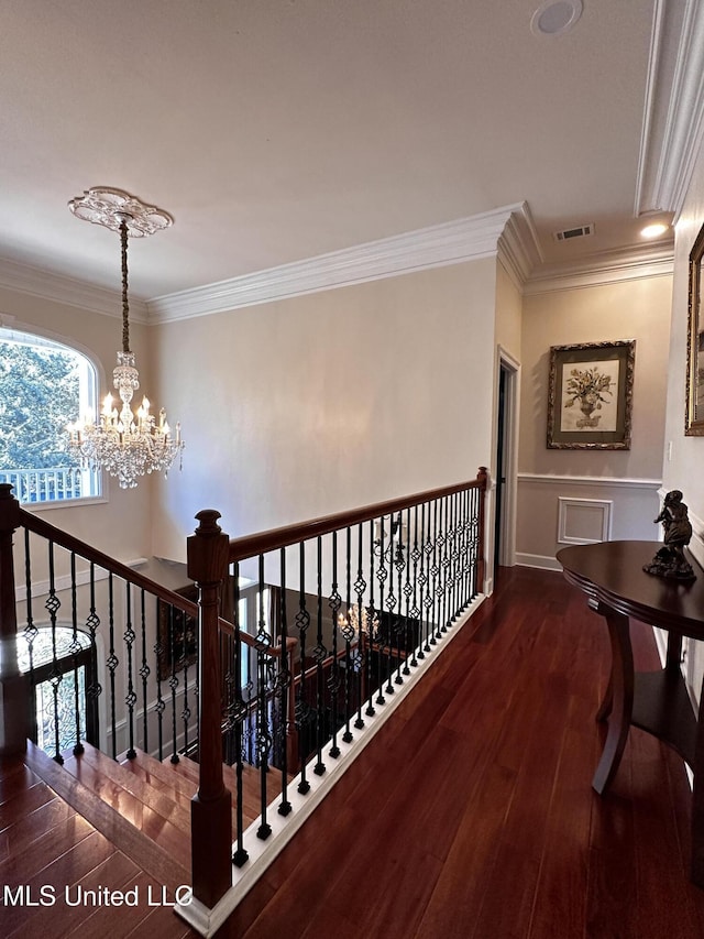 hallway featuring ornamental molding, dark hardwood / wood-style floors, and a notable chandelier