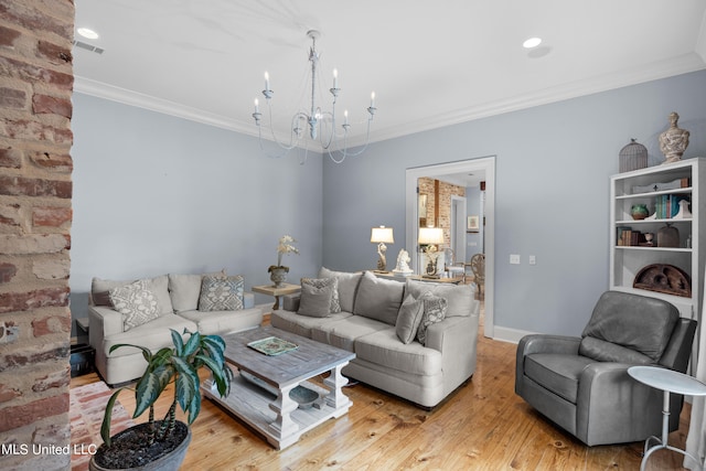 living room with light hardwood / wood-style floors, a notable chandelier, and ornamental molding