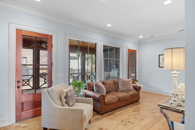 living room featuring crown molding and light wood-type flooring