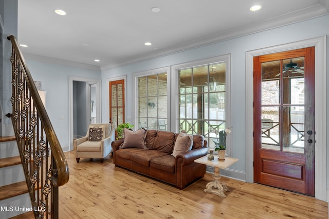 living room with light hardwood / wood-style floors and crown molding