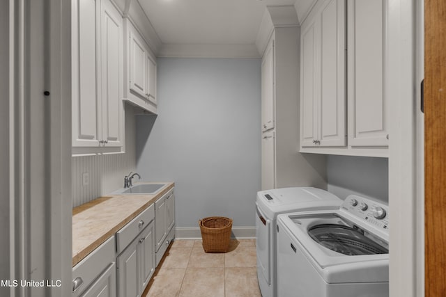 clothes washing area with independent washer and dryer, ornamental molding, sink, light tile patterned floors, and cabinets