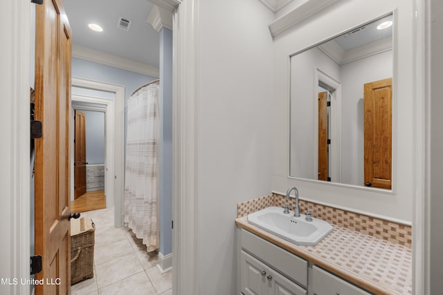 bathroom featuring vanity, ornamental molding, and tile patterned flooring