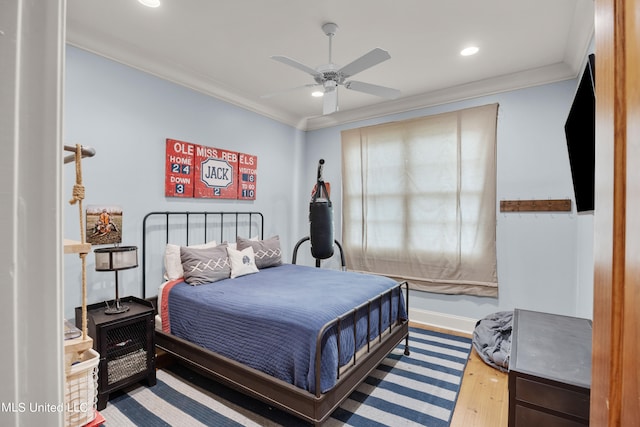 bedroom with crown molding, hardwood / wood-style flooring, and ceiling fan