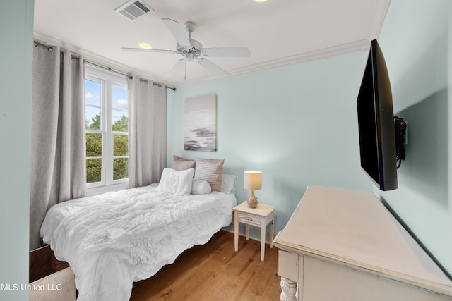 bedroom with light hardwood / wood-style floors, crown molding, and ceiling fan