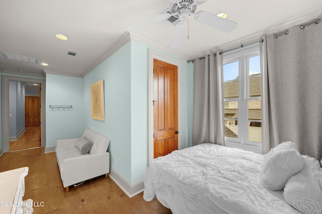 bedroom featuring ceiling fan, ornamental molding, and light hardwood / wood-style flooring