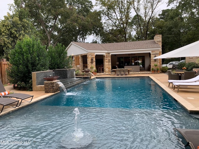 outdoor pool with an outbuilding, a patio area, fence, and a storage structure