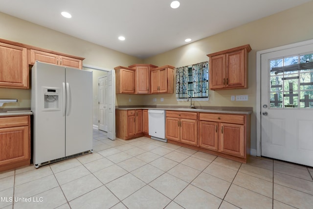 kitchen with sink, light tile patterned flooring, and white appliances