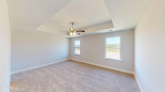 7881 Gardendale Dr, Olive Branch, MS 38654 - empty room featuring a tray ceiling, light colored carpet, and a ceiling fan