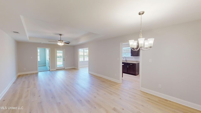 7881 Gardendale Dr, Olive Branch, MS 38654 - empty room with a chandelier, light wood finished floors, a raised ceiling, and ceiling fan