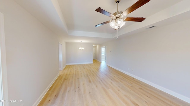 7881 Gardendale Dr, Olive Branch, MS 38654 - unfurnished room featuring a tray ceiling, light wood finished floors, a chandelier, and ceiling fan
