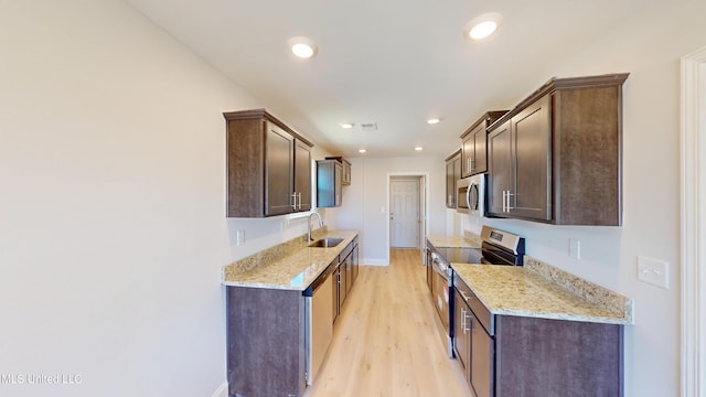 7881 Gardendale Dr, Olive Branch, MS 38654 - kitchen featuring appliances with stainless steel finishes, dark brown cabinets, light wood-style flooring, recessed lighting, and light stone counters