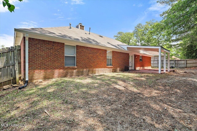 128 Chestnut Dr, Brandon, MS 39047 - back of property featuring brick siding, a fenced backyard, a chimney, and a patio area