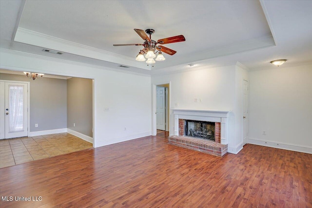 128 Chestnut Dr, Brandon, MS 39047 - unfurnished living room with a raised ceiling, wood finished floors, a ceiling fan, ornamental molding, and a fireplace