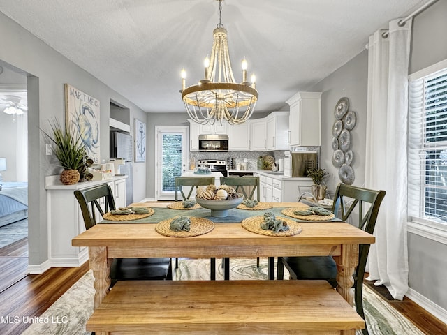 239 Palmetto Ln, Gulfport, MS 39507 - dining area with a chandelier, baseboards, and dark wood-style floors