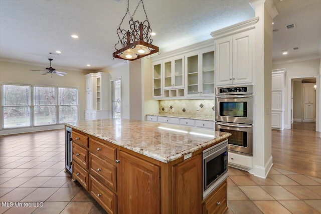 kitchen featuring tile patterned floors, wine cooler, ornamental molding, and stainless steel appliances