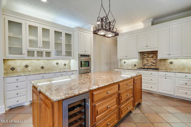 kitchen with stainless steel double oven, beverage cooler, ornamental molding, and gas stovetop