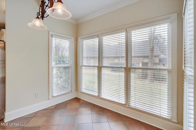 unfurnished dining area featuring crown molding, baseboards, and tile patterned floors