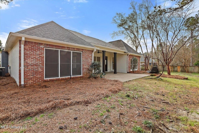 rear view of property featuring a patio, fence, a ceiling fan, roof with shingles, and brick siding