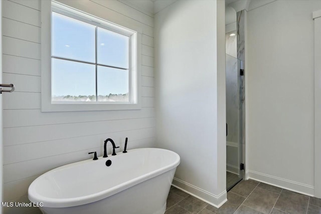 full bath with a soaking tub, baseboards, a stall shower, and tile patterned floors