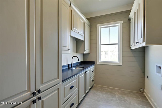 kitchen with dark countertops, baseboards, and a sink