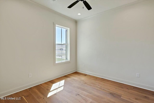 empty room featuring ornamental molding, a ceiling fan, baseboards, and wood finished floors