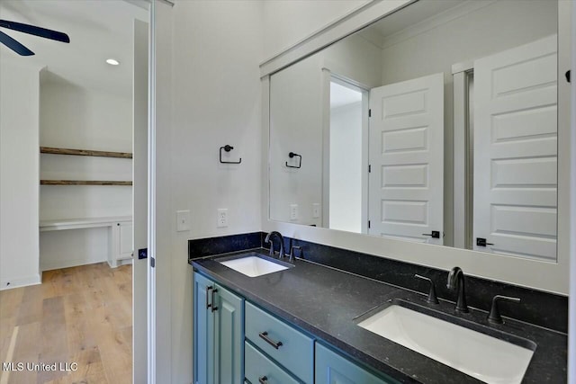 full bathroom with baseboards, wood finished floors, ceiling fan, and a sink