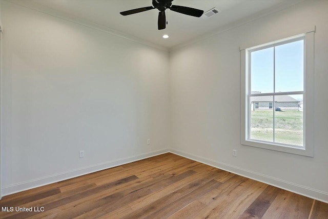 empty room with wood finished floors, visible vents, baseboards, recessed lighting, and crown molding