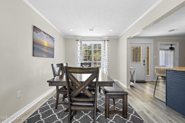 114 Olson Ave, Long Beach, MS 39560 - dining area with wood finished floors, baseboards, crown molding, a textured ceiling, and recessed lighting