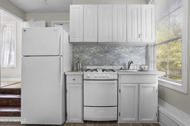 114 Olson Ave, Long Beach, MS 39560 - kitchen with white appliances, white cabinets, a sink, decorative backsplash, and light countertops