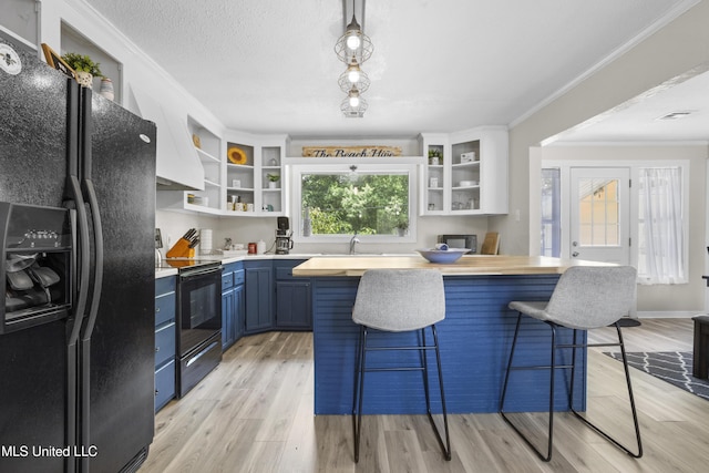114 Olson Ave, Long Beach, MS 39560 - kitchen featuring black appliances, blue cabinets, open shelves, a breakfast bar, and butcher block countertops