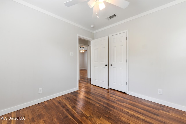 unfurnished bedroom with ornamental molding, dark hardwood / wood-style floors, a closet, and ceiling fan