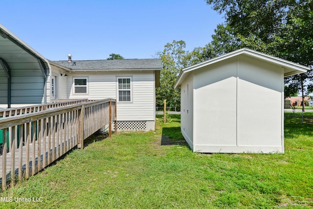 rear view of house with a wooden deck and a lawn