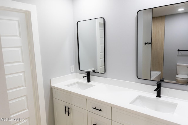full bath featuring toilet and double vanity