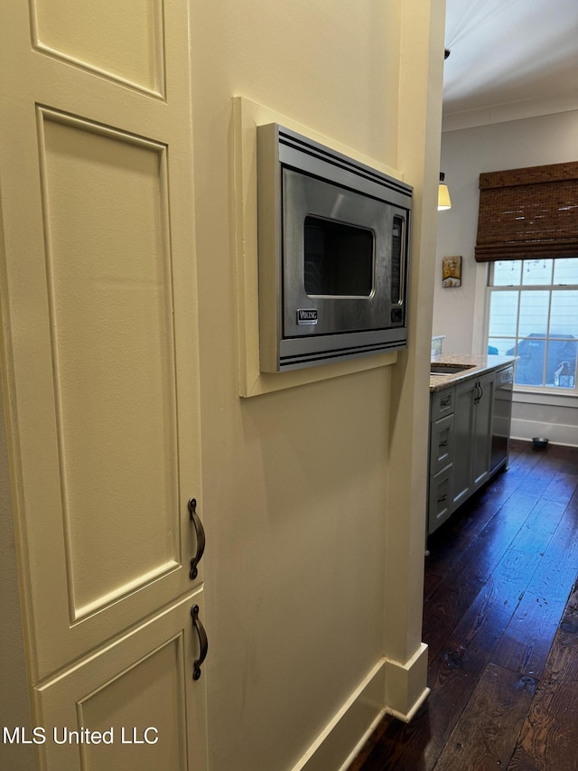 room details featuring stainless steel microwave and wood-type flooring