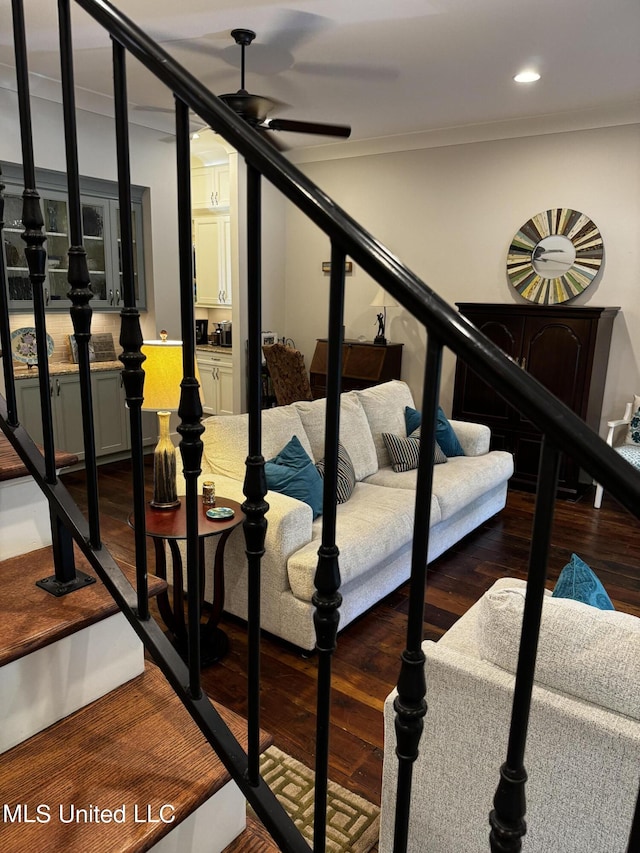 stairway with crown molding, ceiling fan, and wood-type flooring