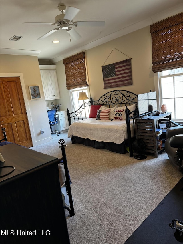 carpeted bedroom with crown molding, ceiling fan, and multiple windows