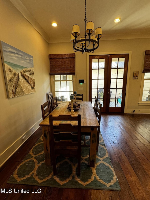 dining room featuring dark hardwood / wood-style flooring, crown molding, french doors, and a chandelier