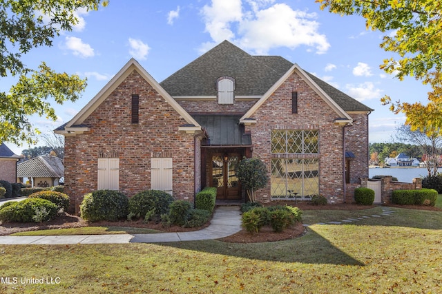 view of property featuring french doors and a front lawn