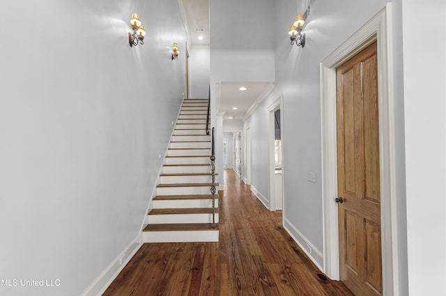 staircase with wood-type flooring and crown molding