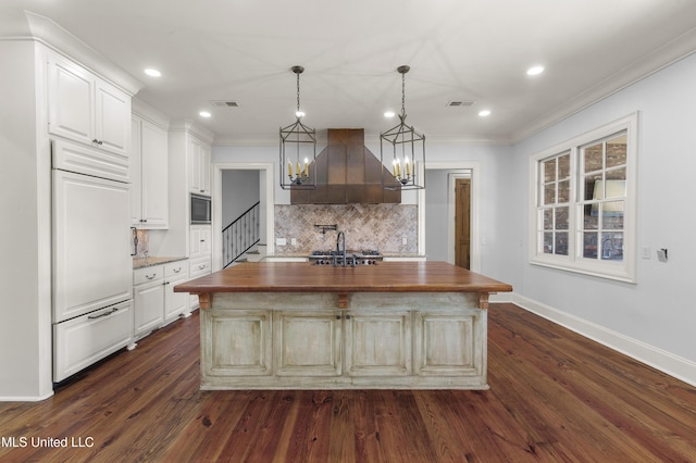 kitchen with a center island, ventilation hood, built in appliances, dark hardwood / wood-style floors, and butcher block counters