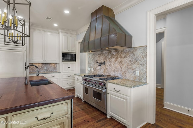 kitchen with black microwave, sink, range with two ovens, white cabinets, and custom exhaust hood