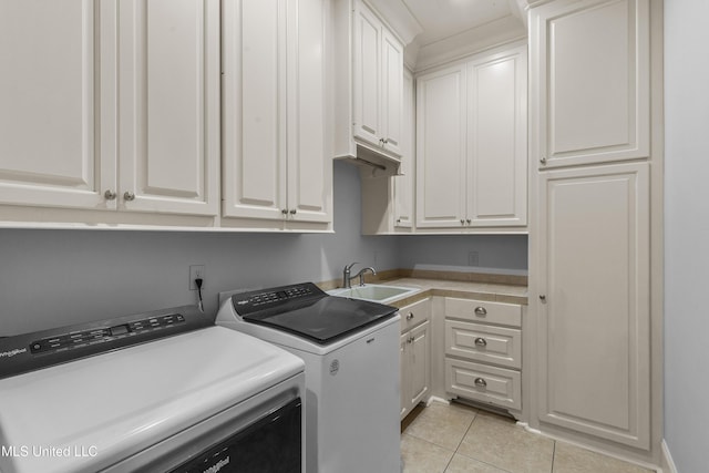 washroom featuring washer and clothes dryer, sink, light tile patterned flooring, and cabinets